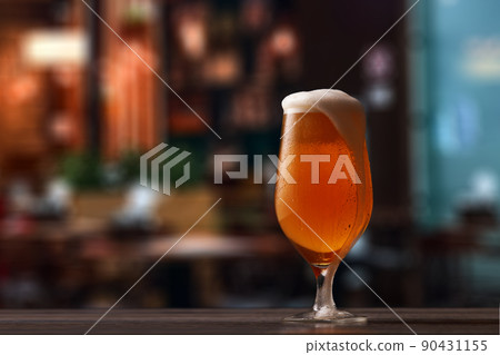 Tulip glass of beer on counter in pub. Tulip glass of beer on counter in pub. 90431155