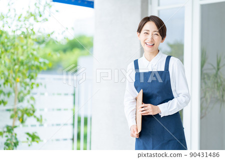 在入口處迎接顧客的女店員。 90431486