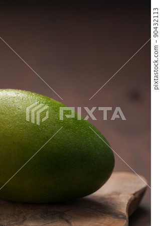 Ripe green mango washed and ready to eat on wood board 90432113