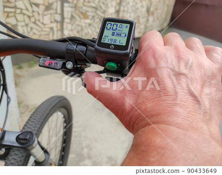 Male hand on the trigger electronic accelerator of electric bike Male hand on the trigger electronic accelerator of electric bike 90433649
