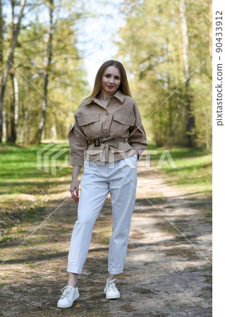 Girl in a jacket walking in the park Girl in a jacket walking in the park 90433912