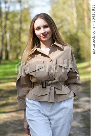 Girl in a jacket walking in the park Girl in a jacket walking in the park 90433913