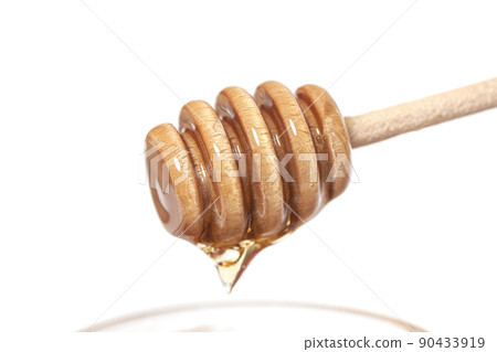 Honey dripping from honey dipper. Healthy food concept 90433919