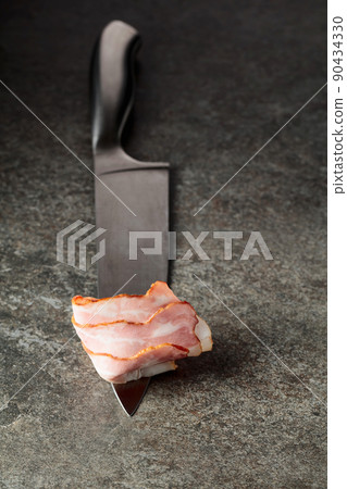 Bacon on a kitchen knife. 90434330