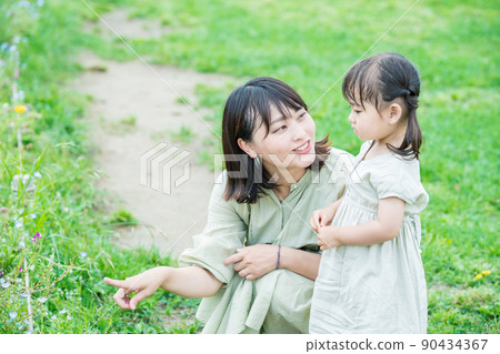 Parent and child playing in the park 90434367