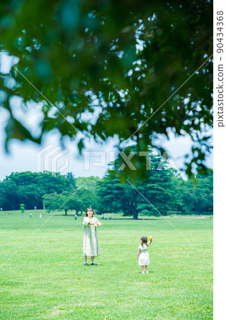 Parent and child playing in the park 90434368