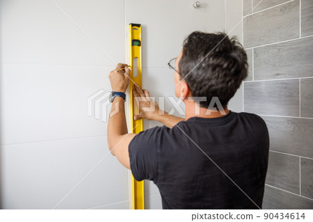 A man is doing repairs in the bathroom. A man is doing repairs in the bathroom. 90434614