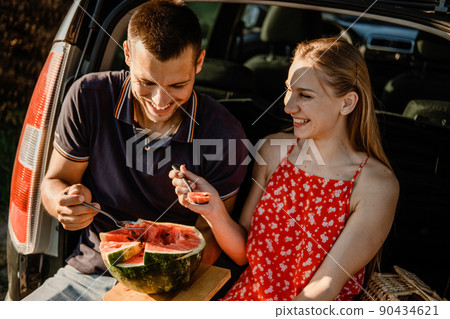 Local travel, Romantic Picnic Date Ideas. couple in love on summer picnic with watermelon in car trunk Local travel, Romantic Picnic Date Ideas. couple in love on summer picnic with watermelon in car trunk 90434621