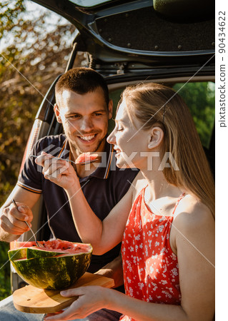 Local travel, Romantic Picnic Date Ideas. couple in love on summer picnic with watermelon in car trunk 90434622