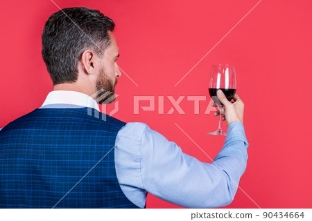 handsome sommelier in formal wear hold glass of red wine for drinking, greeting 90434664