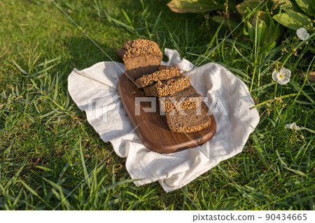 Composition of homemade custard bread on wood board with white cloth napkin on the green grass. High quality photo Composition of homemade custard bread on wood board with white cloth napkin on the green grass. High quality photo 90434665