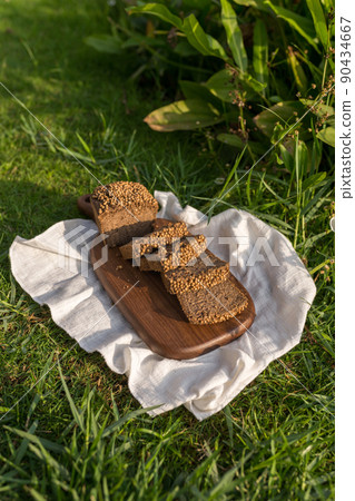 Composition of homemade custard bread on wood board with white cloth napkin on the green grass. High quality photo 90434667