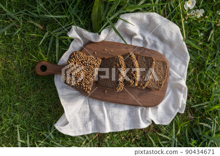 Composition of homemade custard bread on wood board with white cloth napkin on the green grass. High quality photo 90434671
