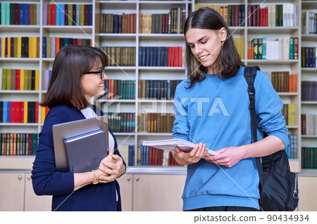 Talking female teacher and guy college student, in the library room Talking female teacher and guy college student, in the library room 90434934