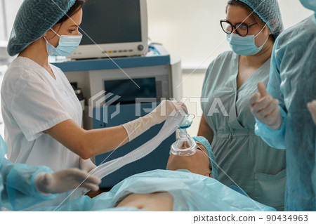 Well-trained anesthesiologist follows the patient during the surgery in clinic 90434963