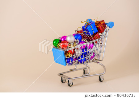 Shopping cart with multicolored christmas balls for decorating christmas tree 90436733