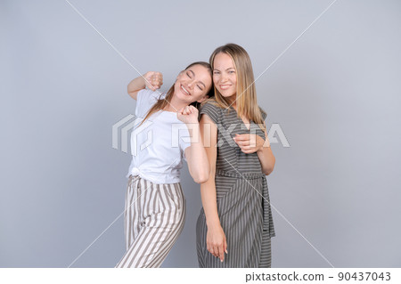 Mother and daughter are hugging and having fun together on background in studio 90437043