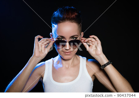 Close up portrait of cool short haired woman holding hands on stylish round 90437044