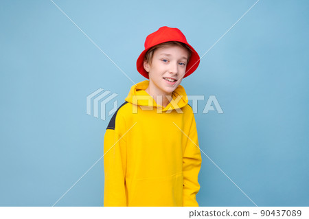 Portrait surprised young guy in yellow sweater and red panama hat on a blue Portrait surprised young guy in yellow sweater and red panama hat on a blue 90437089