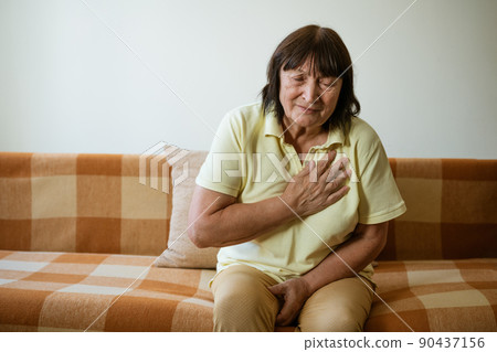 Mature woman holding her heart with her hand Mature woman holding her heart with her hand 90437156