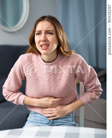 Young woman suffering from abdominal pain Young woman suffering from abdominal pain 90438287