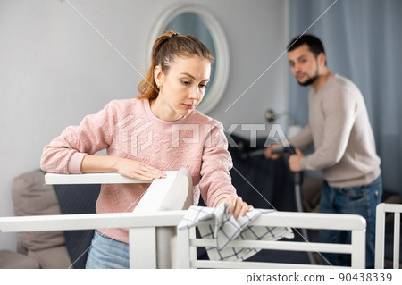 Young couple cleaning table in living room Young couple cleaning table in living room 90438339