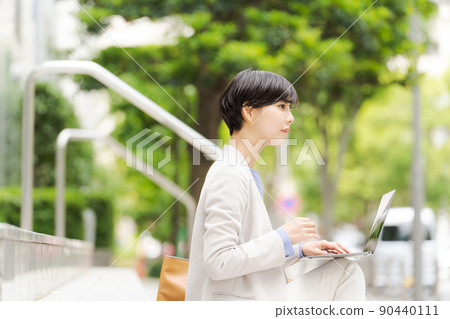 一個女人在樓梯上操作電腦 一個女人在樓梯上操作電腦 90440111