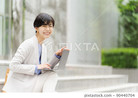 一個女人在樓梯上操作電腦 一個女人在樓梯上操作電腦 90440704