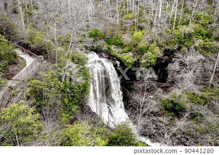 A scenic waterfall roadside going over the cliff down to the boulders and rocks below where you can no longer drive under but can walk underneath the raging waters A scenic waterfall roadside going over the cliff down to the boulders and rocks below where you can no longer drive under but can walk underneath the raging waters 90441280