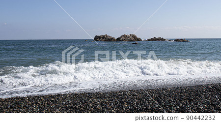 藍海中強烈的海浪沖擊著海灘上的岩石，白色泡沫被擾亂 90442232
