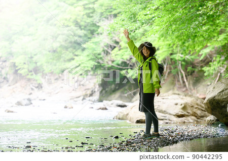 People taking a walk along the mountain stream 90442295