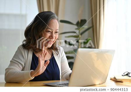 Happy asian aged woman using laptop computer to video call with her family. Happy asian aged woman using laptop computer to video call with her family. 90444313