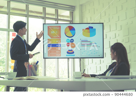 Businessman is presenting work and flowchart on television monitor screen in a conference room. 90444680