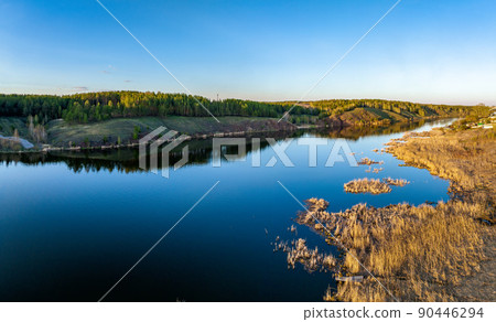 Beauriful sunset view along the Iset river and rocks near Kamensk-Uralskiy. A scenic sunset at the river. Kamensk-Uralskiy, Sverdlovsk region, Ural mountains, Russia. Aerial view 90446294