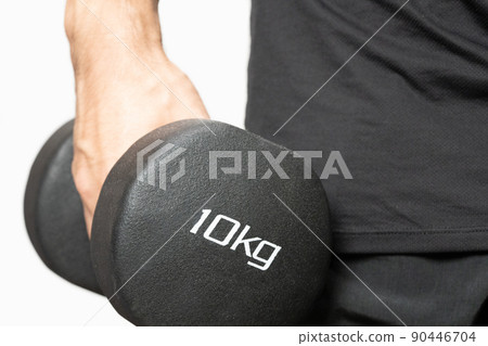 A man doing muscle training with a 10 kg dumbbell 90446704