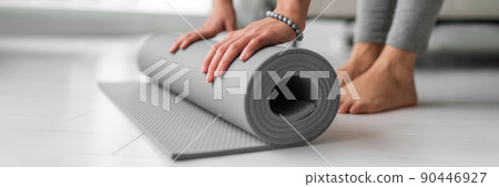 Yoga online class at home woman rolling mat on apartment floor for gym training or meditation banner panoramic. Feet and hands closeup 90446927