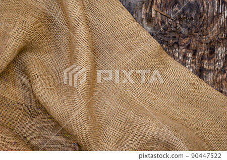 Rough Fabric Sackcloth on Dark Wooden Background. Rough Fabric Sackcloth on Dark Wooden Background. 90447522