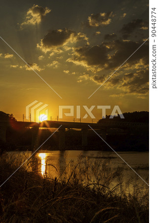 沿河美麗的日落風景和在鐵路橋上行駛的火車 90448774