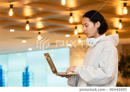 Men in headphones with a laptop Men in headphones with a laptop 90448995