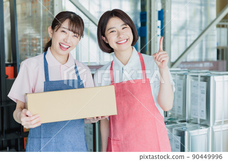 Female staff cheerfully working in a warehouse 90449996