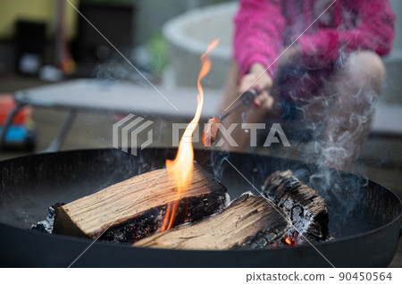 Grilling a hotdog in a n open fire 90450564
