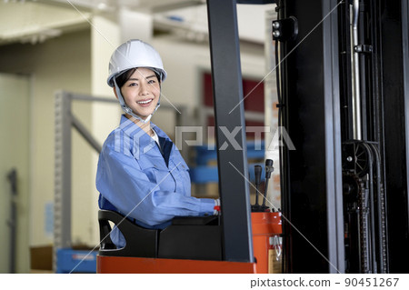 Female forklift operator looking at the camera smile portrait Female forklift operator looking at the camera smile portrait 90451267