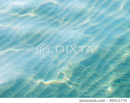 An image photograph of the shallow sea surface with a sandy bottom that glitters in bright sunlight. An image photograph of the shallow sea surface with a sandy bottom that glitters in bright sunlight. 90451770
