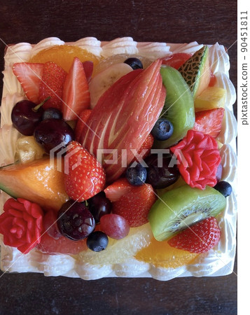 一個華麗的方形生日蛋糕，裡面有很多水果 90451811