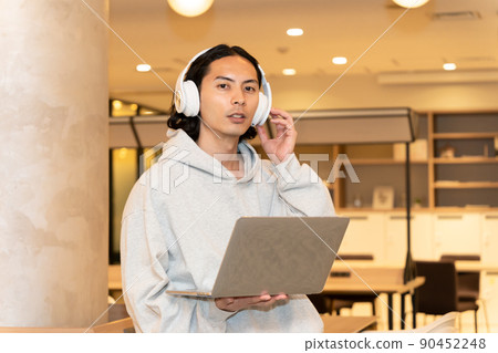 Men in headphones with a laptop Men in headphones with a laptop 90452248