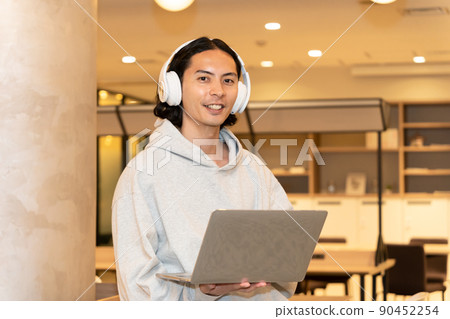 Men in headphones with a laptop Men in headphones with a laptop 90452254