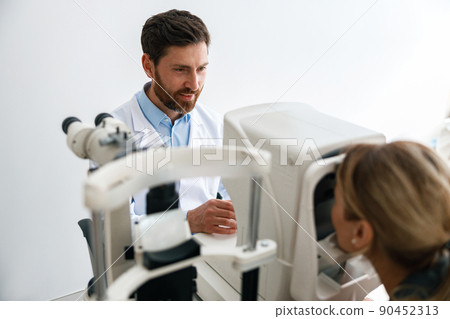 Optometrist checks the patient's intraocular pressure in optician's shop or ophthalmology clinic Optometrist checks the patient's intraocular pressure in optician's shop or ophthalmology clinic 90452313
