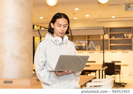 Men in headphones with a laptop Men in headphones with a laptop 90452403