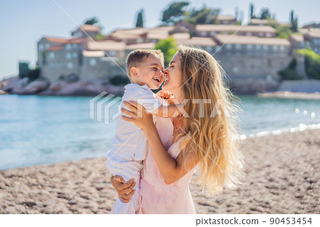 Mother and son tourists on background of beautiful view St. Stephen island, Sveti Stefan on the Budva Riviera, Budva, Montenegro. Travel to Montenegro concept 90453454