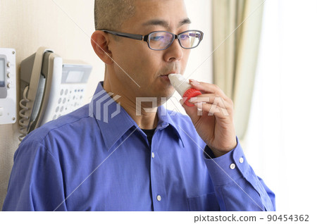 Men using asthma inhalers Men using asthma inhalers 90454362